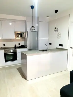 a kitchen with white cabinets and a stainless steel refrigerator at LHOME CÁDIZ in Cádiz