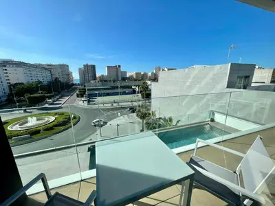 a balcony with a table and chairs and a view of a city at LHOME CÁDIZ in Cádiz