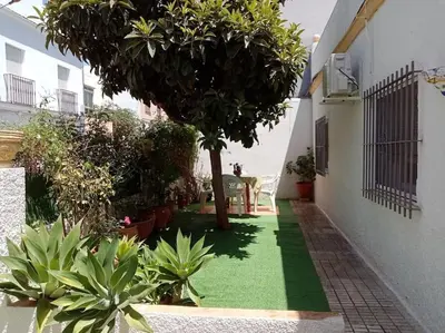 a garden with a green lawn next to a building at Casa tranquila , muy bien ubicada in Chiclana de la Frontera