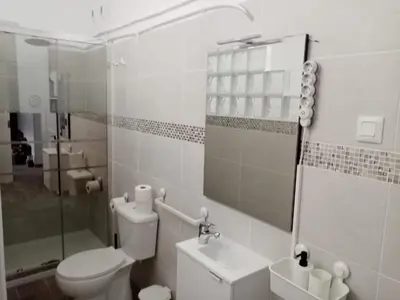a white bathroom with a toilet and a sink at Casa tranquila , muy bien ubicada in Chiclana de la Frontera