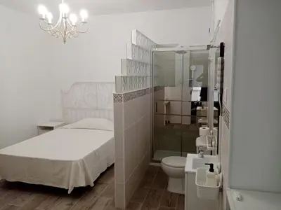 a bathroom with a bed and a shower and a toilet at Casa tranquila , muy bien ubicada in Chiclana de la Frontera