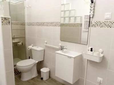 a white bathroom with a toilet and a sink at Casa tranquila , muy bien ubicada in Chiclana de la Frontera