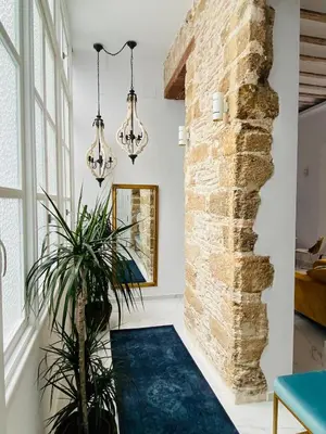 a room with a brick wall and a blue carpet at inncadizcasa Señorial de Rivadavia in Cádiz