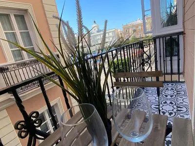a balcony with two chairs and a potted plant at inncadizcasa Señorial de Rivadavia in Cádiz