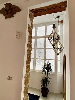 a hallway with a window and a chandelier at inncadizcasa Señorial de Rivadavia in Cádiz