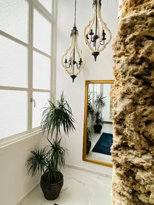 a living room with two chandeliers and a mirror at inncadizcasa Señorial de Rivadavia in Cádiz