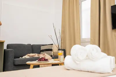a living room with a couch and a table with towels at Apartamentos La Tahona Cádiz Centro in Cádiz