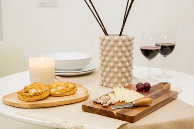 a table with a plate of food and glasses of wine at Apartamentos La Tahona Cádiz Centro in Cádiz