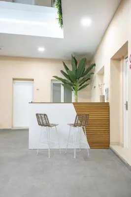 two chairs and a counter in a building with a plant at Apartamentos La Tahona Cádiz Centro in Cádiz