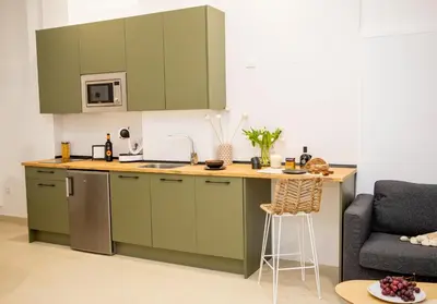 a kitchen with green cabinets and a counter top at Apartamentos La Tahona Cádiz Centro in Cádiz