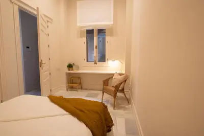 a bedroom with a bed and a window and a chair at inncadizCasa Apolo in Cádiz