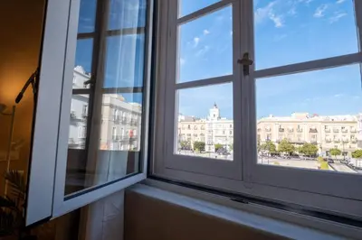 an open window with a view of a city at inncadizCasa Apolo in Cádiz