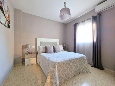 a bedroom with a large bed and a window at Apartamento Alférez in Sanlúcar de Barrameda