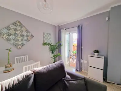 a living room with a couch and a window at Apartamento Alférez in Sanlúcar de Barrameda