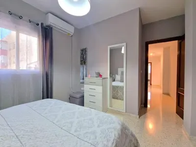 a bedroom with a bed and a dresser and a mirror at Apartamento Alférez in Sanlúcar de Barrameda