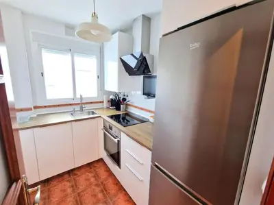 a kitchen with a large stainless steel refrigerator at Apartamento Alférez in Sanlúcar de Barrameda