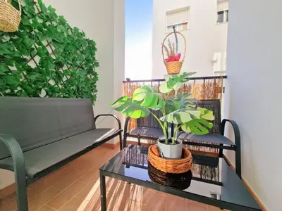 a living room with a couch and a table with plants at Apartamento Alférez in Sanlúcar de Barrameda