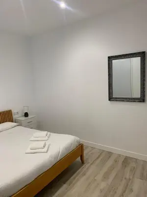 a bedroom with a bed with a mirror on the wall at Luna Alameda Grupo AC Gestion in Cádiz