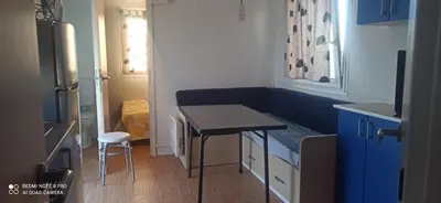 a small kitchen with a table and a stool at Tiny house Chill escape para 7 - private Jacussy Brisa & Burbujas in Chiclana de la Frontera