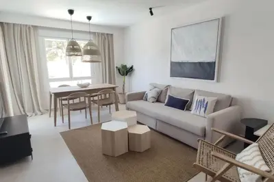 a living room with a couch and a table at Piso reformado de diseño c/terraza. Playa el Ancla in El Puerto de Santa María