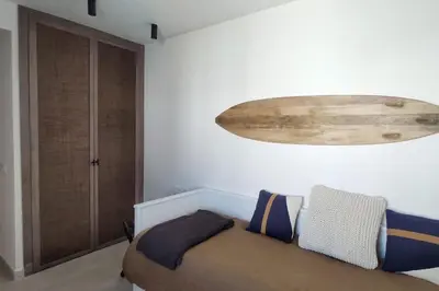 a bedroom with a bed and a large chandelier at Piso reformado de diseño c/terraza. Playa el Ancla in El Puerto de Santa María