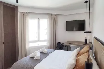 a bedroom with a bed with towels on it at Piso reformado de diseño c/terraza. Playa el Ancla in El Puerto de Santa María