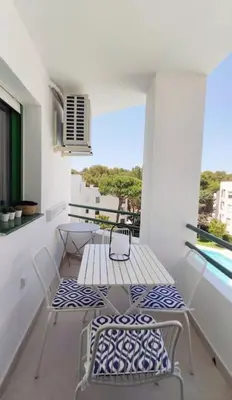 a balcony with a table and chairs and a window at Piso reformado de diseño c/terraza. Playa el Ancla in El Puerto de Santa María