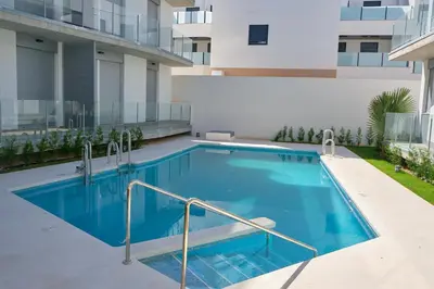 a swimming pool in the middle of a building at Viento Grande, Apartamento boutique en la playa in Rota