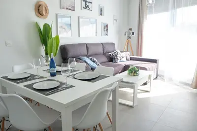a living room with a table and a couch at Viento Grande, Apartamento boutique en la playa in Rota