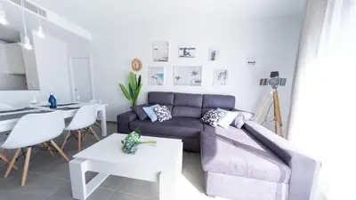 a living room with a couch and a table at Viento Grande, Apartamento boutique en la playa in Rota