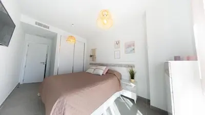 a bedroom with a bed in a white room at Viento Grande, Apartamento boutique en la playa in Rota