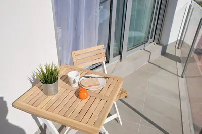 a wooden table with a plate of food on a balcony at Viento Grande, Apartamento boutique en la playa in Rota