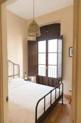 a bedroom with a large bed and a window at Candié by Gades Gestión in Cádiz