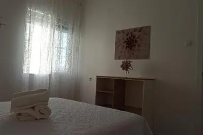 a white bedroom with a bed and a window at Acogedor piso centro, San Miguel in Jerez de la Frontera