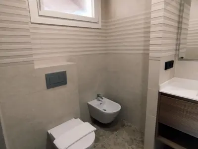 a white bathroom with a toilet and a sink at Gran Casa con Piscina Privada by Chiclana Dreams in Chiclana de la Frontera
