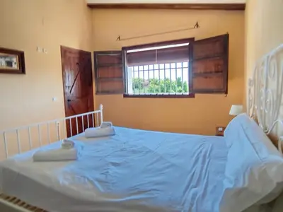 a bedroom with a bed with blue sheets and a window at Gran Casa con Piscina Privada by Chiclana Dreams in Chiclana de la Frontera