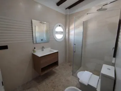 a bathroom with a sink and a glass shower at Gran Casa con Piscina Privada by Chiclana Dreams in Chiclana de la Frontera