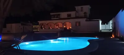 a swimming pool in front of a house at night at CÁDIZ - BUDA, acogedor apartamento en Chiclana de la Frontera, España in Chiclana de la Frontera