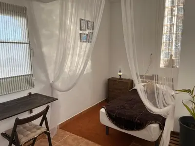 a bedroom with a bed with a mosquito net at CÁDIZ - BUDA, acogedor apartamento en Chiclana de la Frontera, España in Chiclana de la Frontera