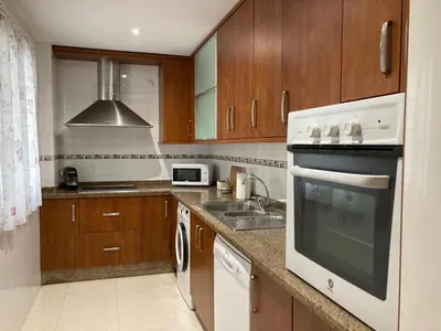 a kitchen with a white stove top oven next to a sink at APARTAMENTO LOS ALTOS DE EL PUERTO - Calidad, Garaje y WiFi in El Puerto de Santa María