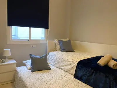 a bedroom with two beds with pillows and a window at APARTAMENTO LOS ALTOS DE EL PUERTO - Calidad, Garaje y WiFi in El Puerto de Santa María