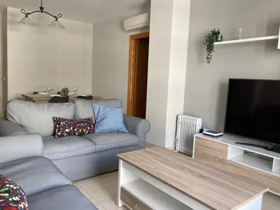 a living room with a couch and a flat screen tv at APARTAMENTO LOS ALTOS DE EL PUERTO - Calidad, Garaje y WiFi in El Puerto de Santa María