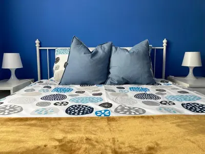 a bed with blue walls and pillows on it at APARTAMENTO LOS ALTOS DE EL PUERTO - Calidad, Garaje y WiFi in El Puerto de Santa María