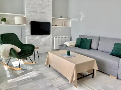 a living room with a couch and a table at ÁTICO VALDELAGRANA PLAYA - Aire Acondicionado y Piscina in El Puerto de Santa María