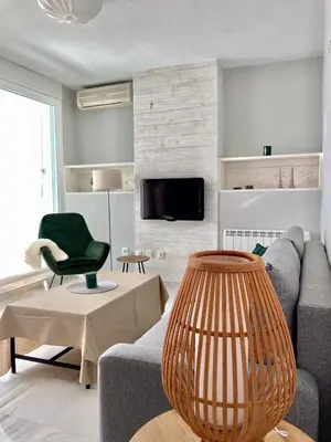 a living room with a couch and a chair at ÁTICO VALDELAGRANA PLAYA - Aire Acondicionado y Piscina in El Puerto de Santa María