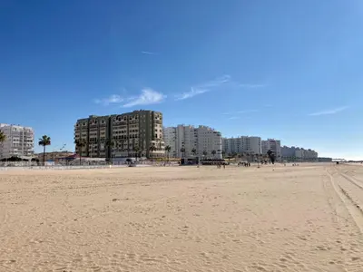 a view of the beach with buildings in the background at ÁTICO VALDELAGRANA PLAYA - Aire Acondicionado y Piscina in El Puerto de Santa María