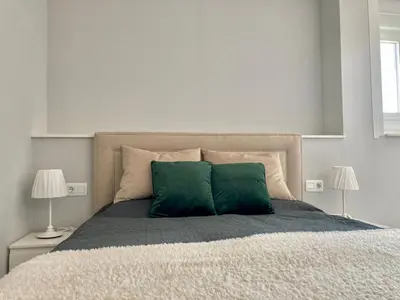 a bedroom with a bed with two green pillows at ÁTICO VALDELAGRANA PLAYA - Aire Acondicionado y Piscina in El Puerto de Santa María