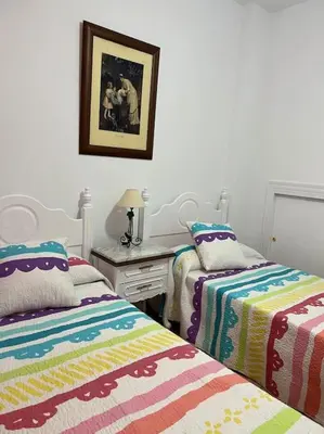 a bedroom with two beds and a desk with a picture at Casa duplex en chipiona in Chipiona