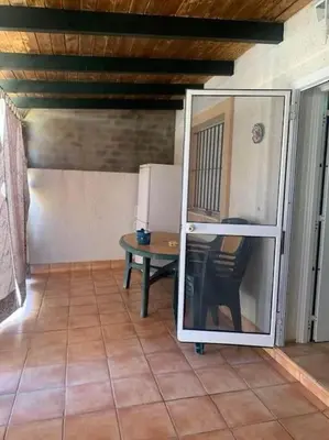 a room with a table and a refrigerator at Casa duplex en chipiona in Chipiona