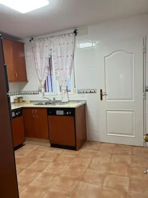 an empty kitchen with a sink and a door at Casa duplex en chipiona in Chipiona
